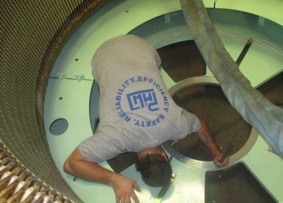 A PMW technician working inside a motor frame