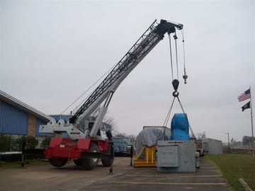 A mobile crane lifting a large motor in the PMW yard