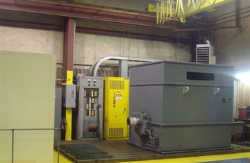 A large motor set up on the PMW test stand beside its control panels