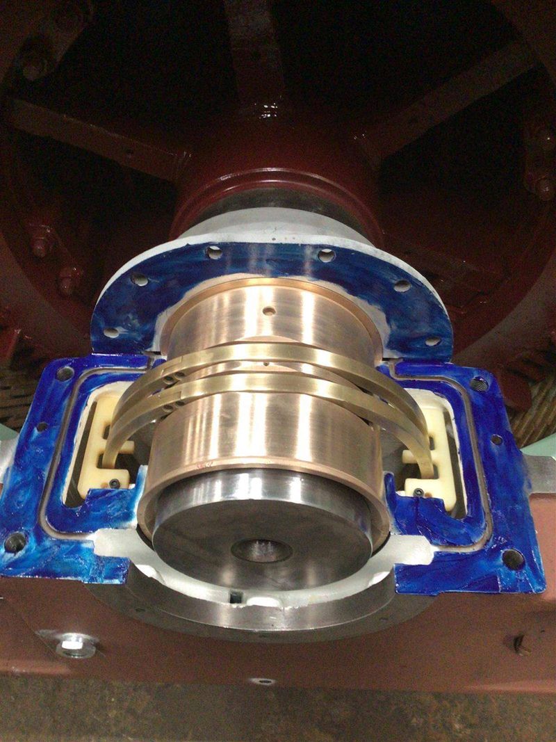 Close-up of bronze bearing segments seated in a blue-painted bearing housing