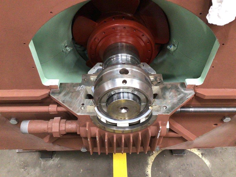 Close-up of bearing housing and polished shaft extending into freshly painted housing