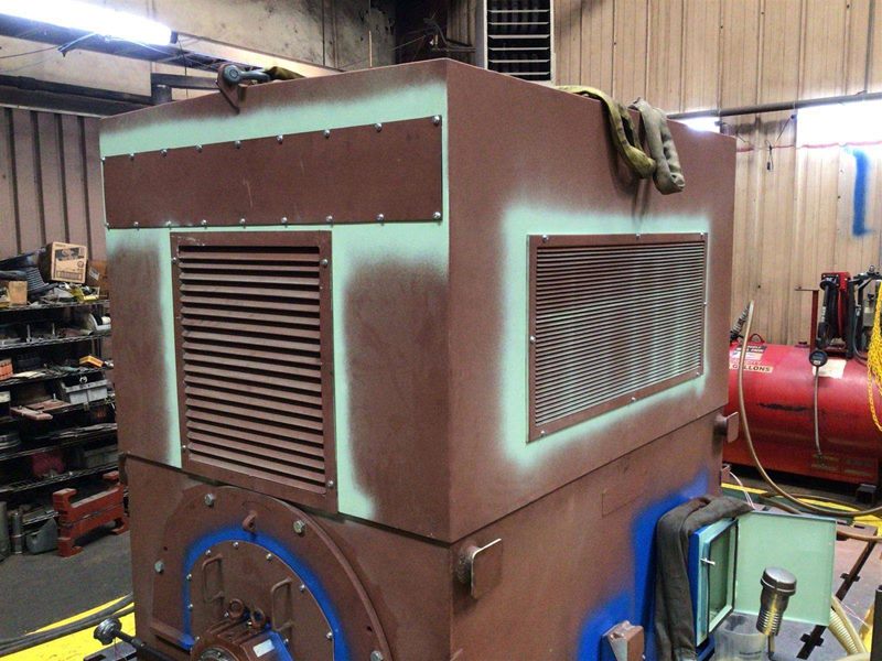 Motor housing during painting with masking tape applied around base and end cover areas