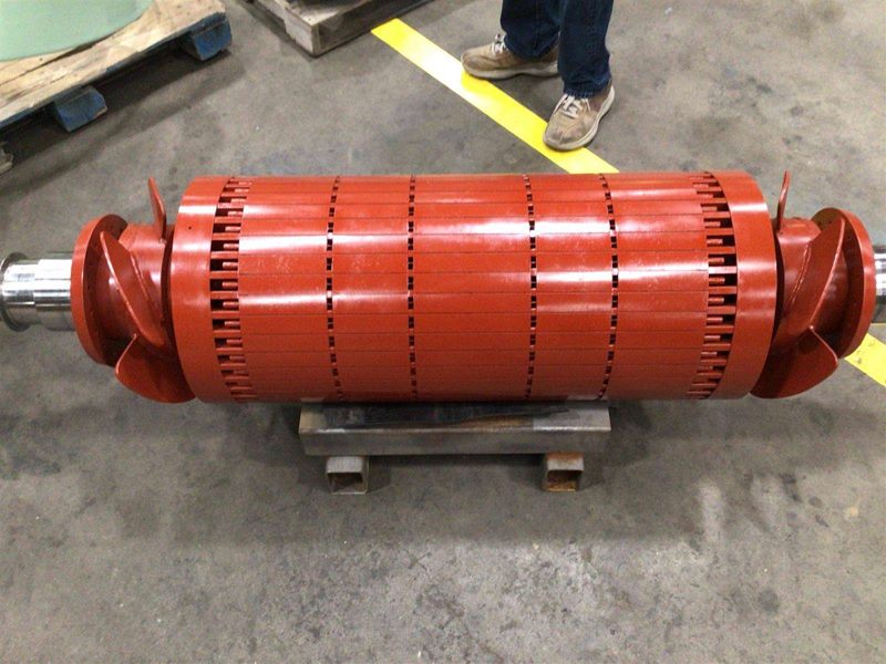 Squirrel cage rotor with laminated core and shaft ends resting on shop supports